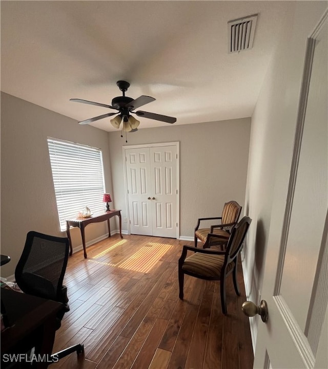 living area featuring hardwood / wood-style floors and ceiling fan