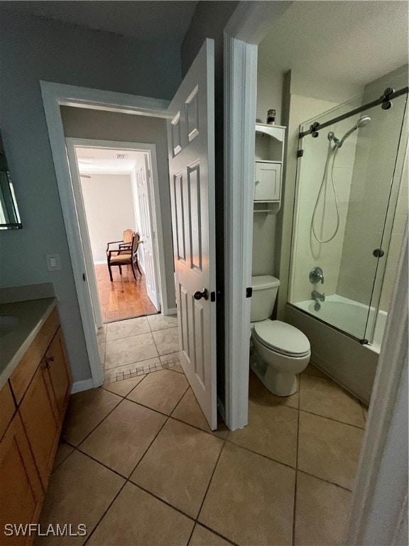 full bathroom with toilet, enclosed tub / shower combo, vanity, and tile patterned flooring