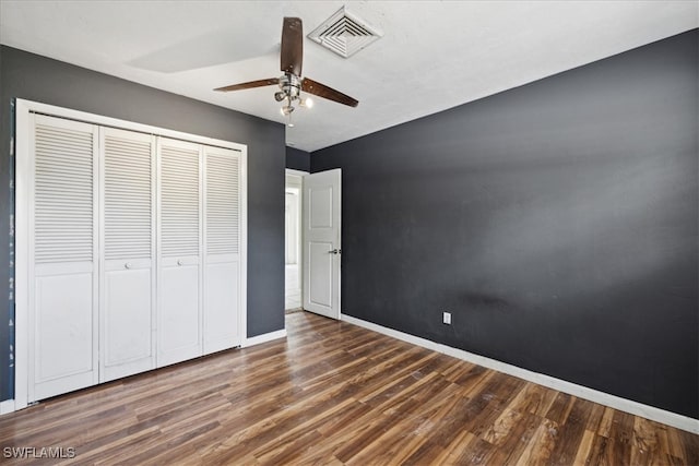 unfurnished bedroom featuring dark wood-type flooring, ceiling fan, and a closet