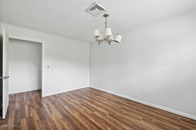 unfurnished room with an inviting chandelier and dark hardwood / wood-style floors