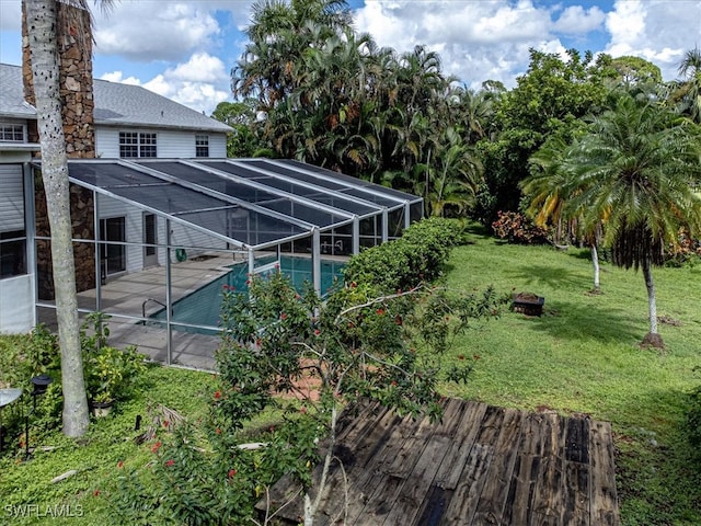 view of yard with glass enclosure, an outdoor fire pit, and a patio area