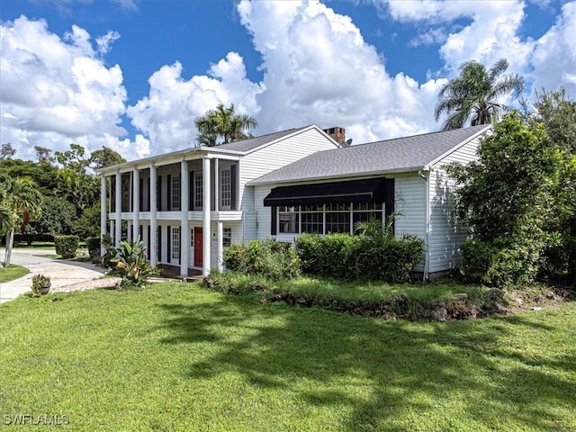 view of front facade featuring a sunroom and a front yard