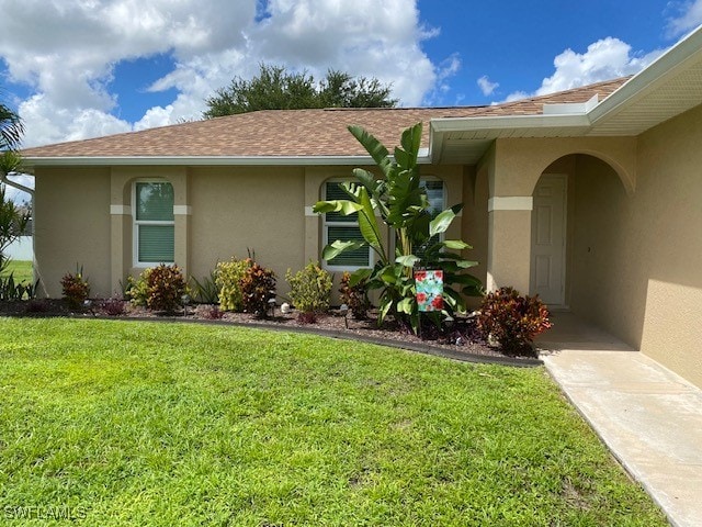 entrance to property with a lawn