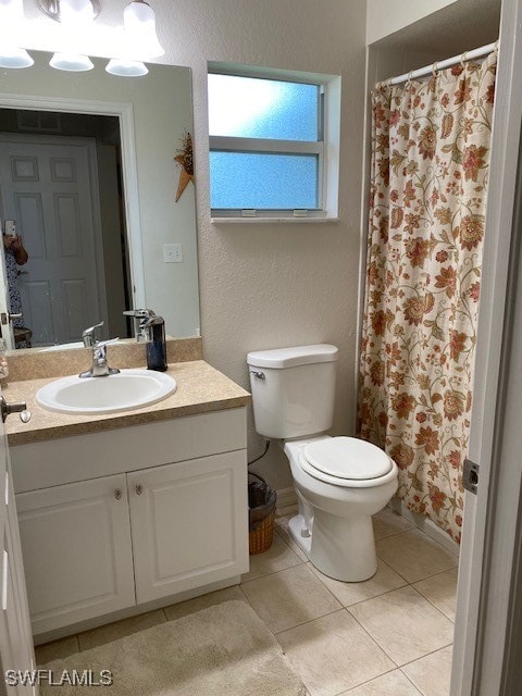 bathroom with toilet, vanity, and tile patterned floors