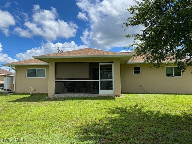 rear view of property featuring a yard