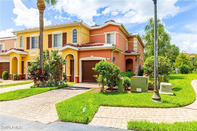 mediterranean / spanish-style house featuring a front yard and a garage