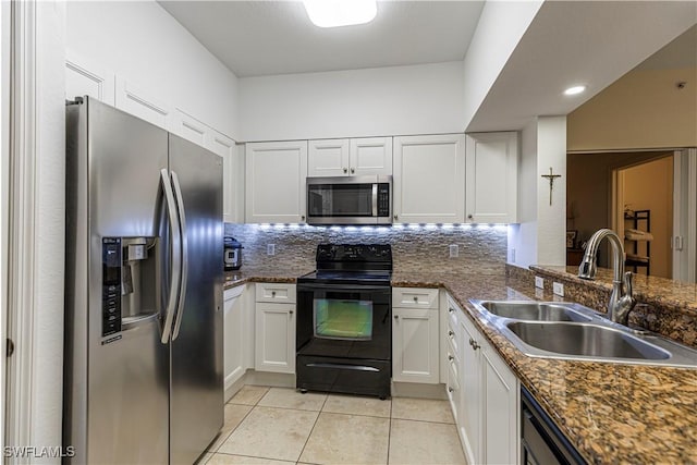 kitchen featuring decorative backsplash, appliances with stainless steel finishes, sink, light tile patterned floors, and white cabinetry