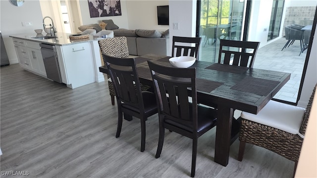 dining space with light wood-type flooring and sink