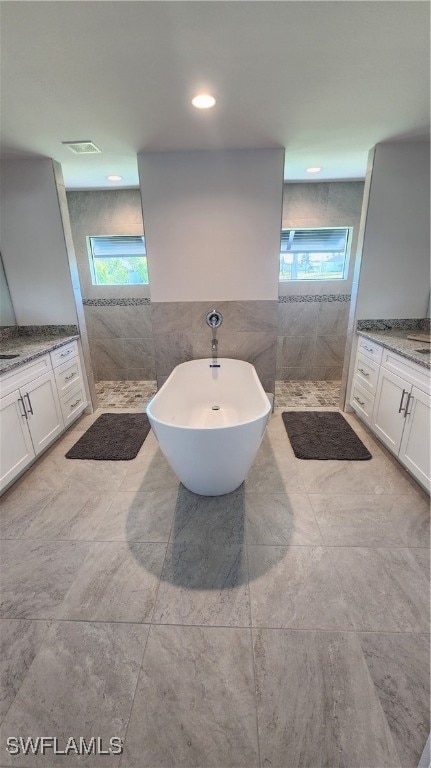 bathroom with vanity, tile walls, independent shower and bath, and tile patterned flooring