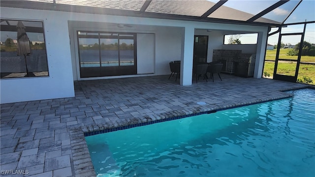 view of pool with ceiling fan, grilling area, a patio, and a lanai