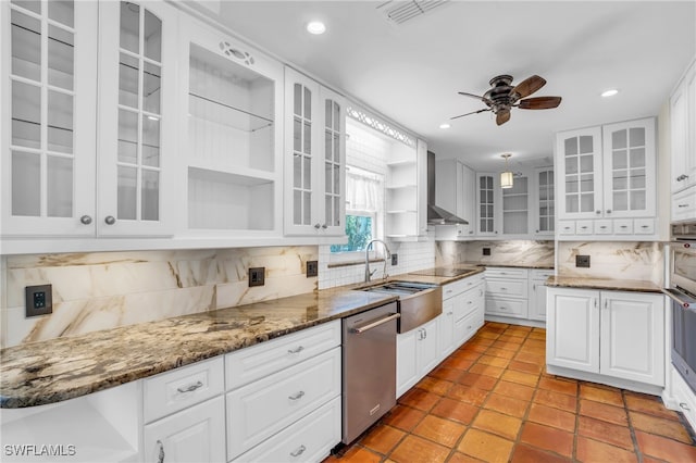 kitchen with decorative backsplash, wall chimney exhaust hood, white cabinets, and dishwasher