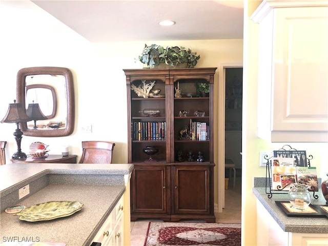 interior space with light tile patterned floors and white cabinets