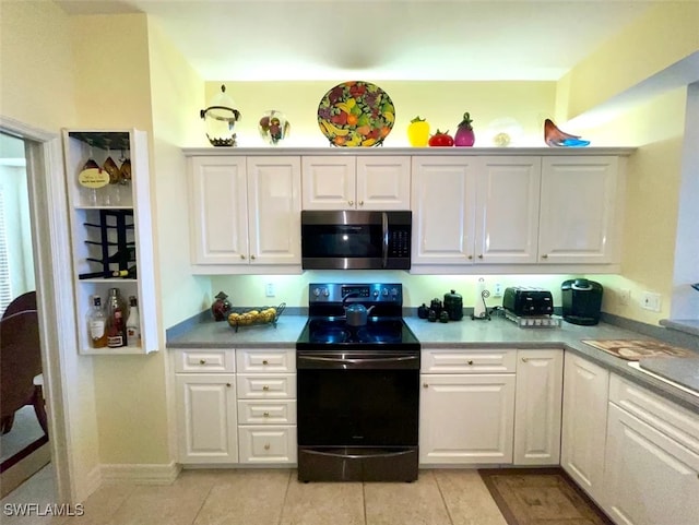 kitchen with range with electric stovetop, light tile patterned floors, and white cabinets