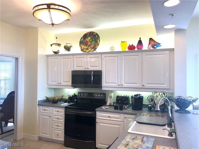 kitchen featuring black appliances, white cabinetry, light tile patterned floors, and sink