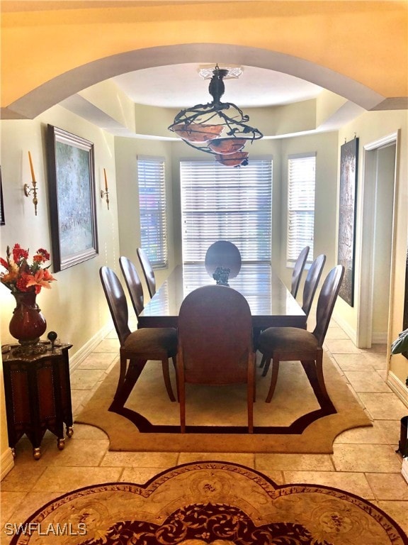 dining room with a chandelier and light tile patterned floors