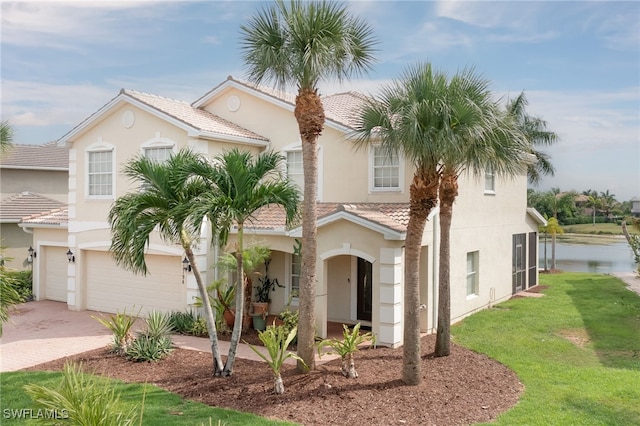 mediterranean / spanish-style home featuring a garage and a front yard