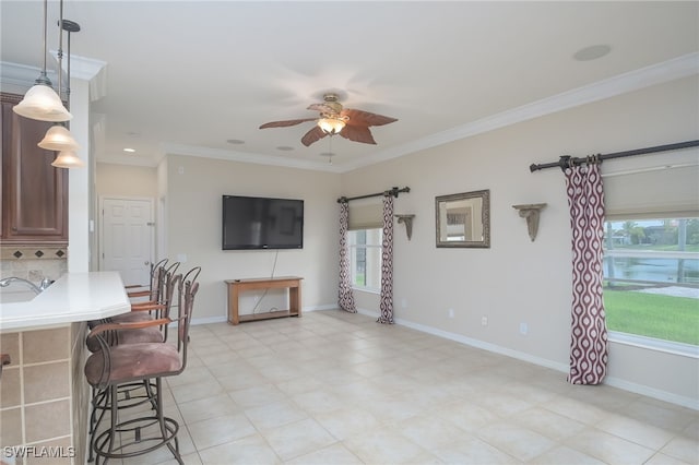 living room with ceiling fan, crown molding, and sink