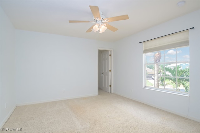 spare room featuring light colored carpet and ceiling fan