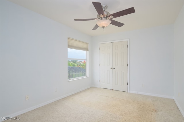 carpeted spare room featuring ceiling fan