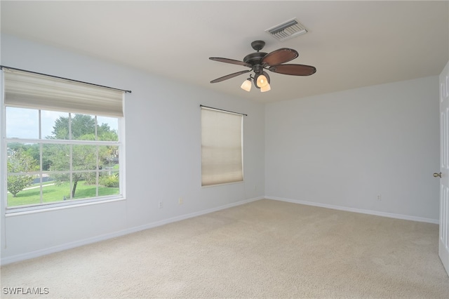 unfurnished room with light colored carpet and ceiling fan