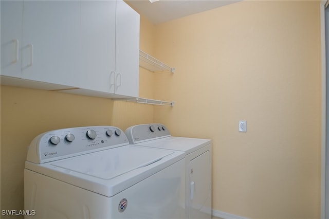 laundry room with independent washer and dryer and cabinets