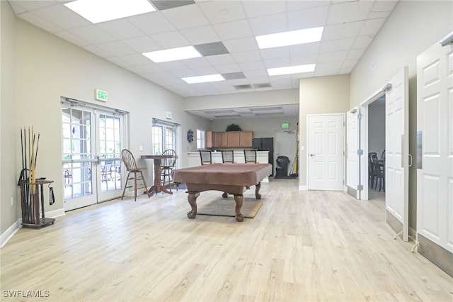 recreation room featuring light hardwood / wood-style flooring, pool table, french doors, and a drop ceiling