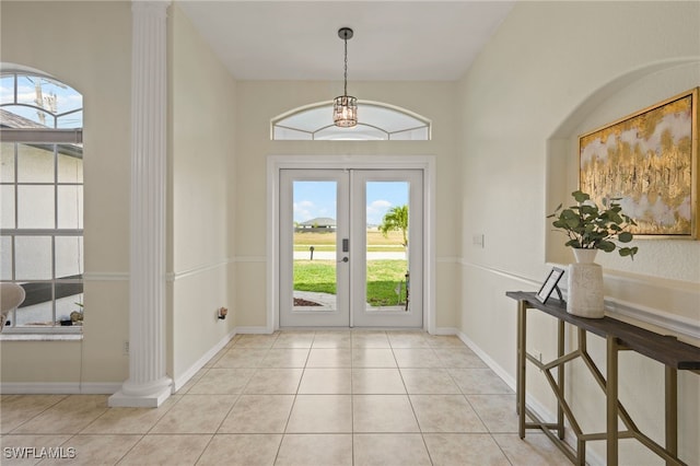 entryway featuring tile patterned floors, decorative columns, french doors, and baseboards