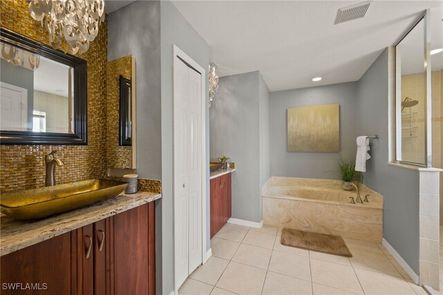 bathroom with tile patterned flooring, vanity, and plus walk in shower