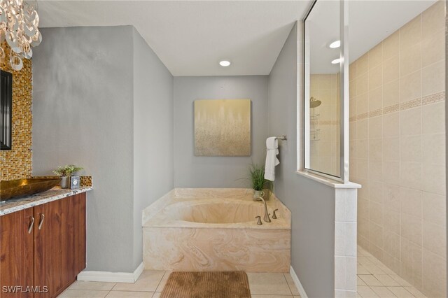 bathroom featuring plus walk in shower, vanity, and tile patterned floors