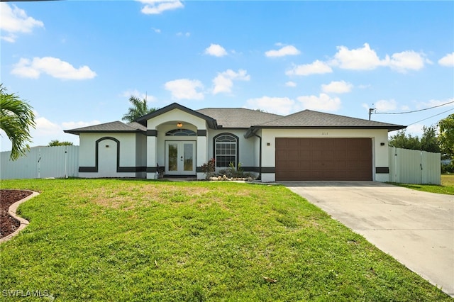 single story home featuring french doors, a front yard, and a garage