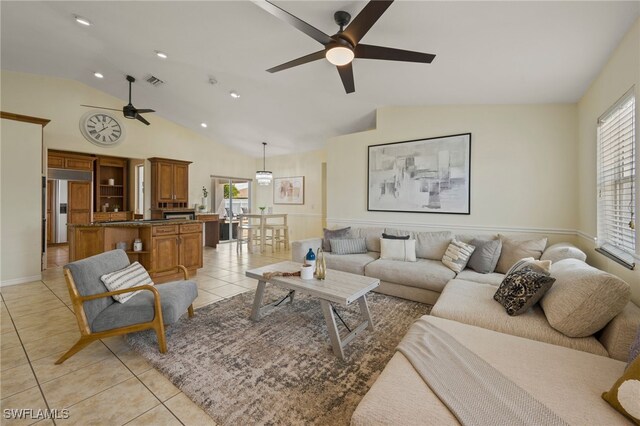 tiled living room featuring ceiling fan and vaulted ceiling