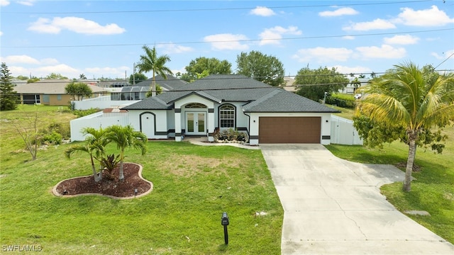 view of front of property with a front lawn, driveway, fence, french doors, and a garage