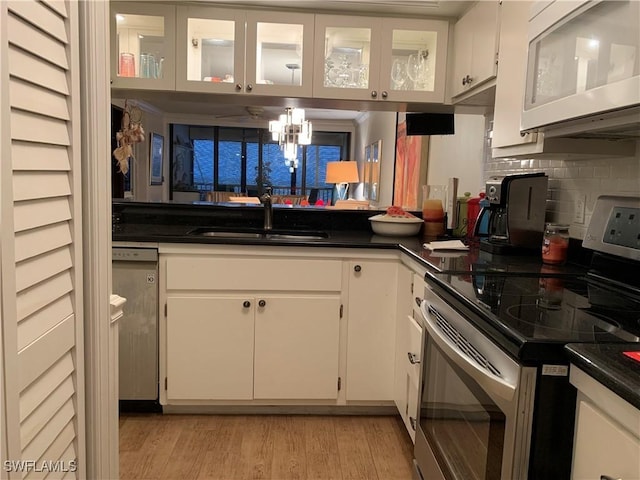 kitchen featuring white cabinets, backsplash, sink, and stainless steel appliances