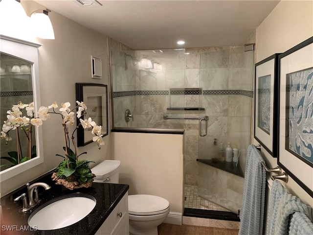 bathroom featuring hardwood / wood-style floors, vanity, toilet, and walk in shower