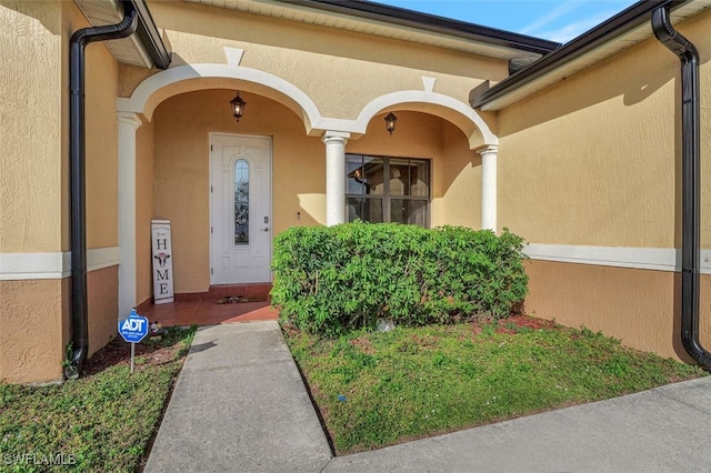 doorway to property featuring stucco siding