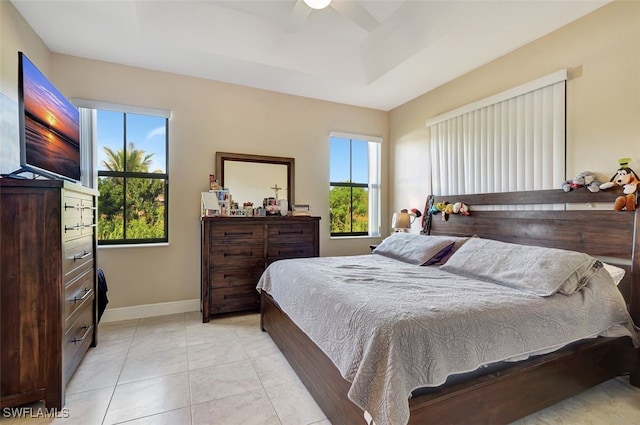 tiled bedroom with multiple windows and ceiling fan