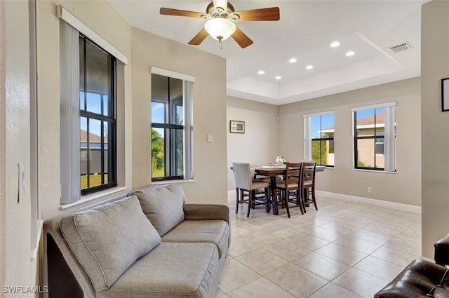 interior space featuring ceiling fan and a raised ceiling