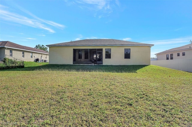 back of property with a lawn