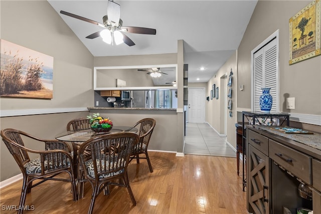 dining space with light hardwood / wood-style floors, lofted ceiling, and ceiling fan