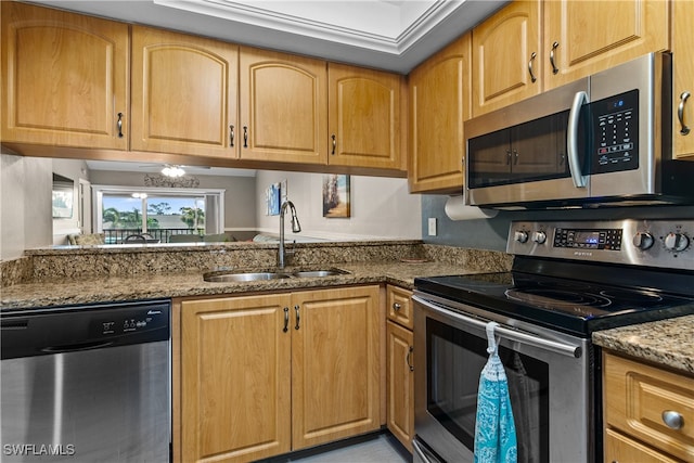 kitchen featuring light stone counters, a notable chandelier, appliances with stainless steel finishes, and sink