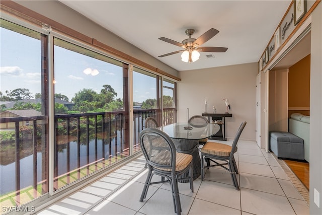 sunroom / solarium with a water view and ceiling fan