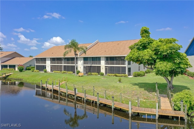 back of property featuring a water view and a yard