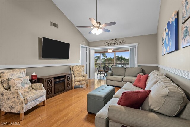 living room featuring ceiling fan, light wood-type flooring, and high vaulted ceiling