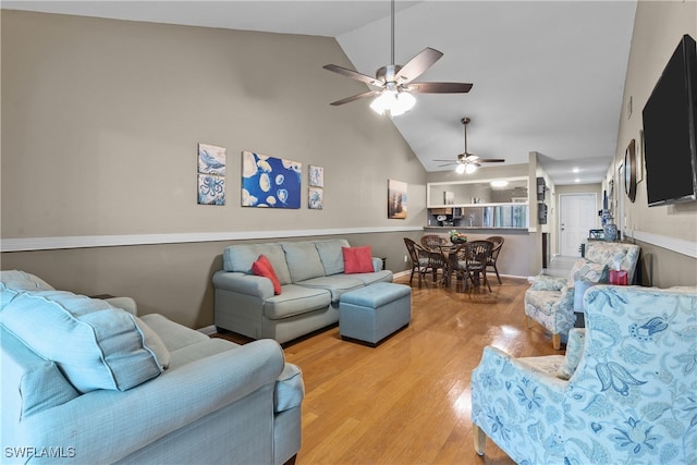 living room with light wood-type flooring, lofted ceiling, and ceiling fan