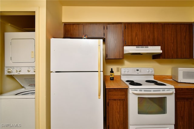 kitchen featuring white appliances and stacked washing maching and dryer