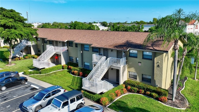 exterior space featuring a balcony and a front yard