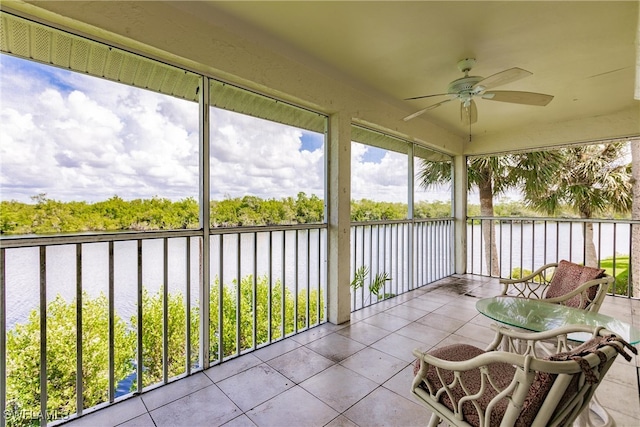 sunroom featuring a water view and ceiling fan