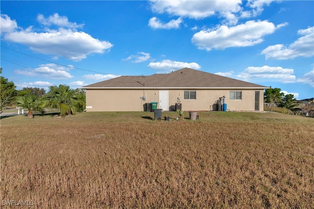 rear view of property featuring a lawn