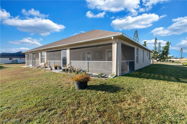 view of side of property with a lawn and a sunroom