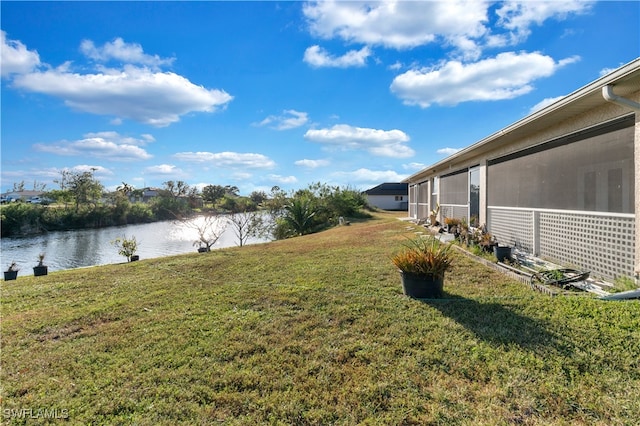 view of yard featuring a water view and a sunroom